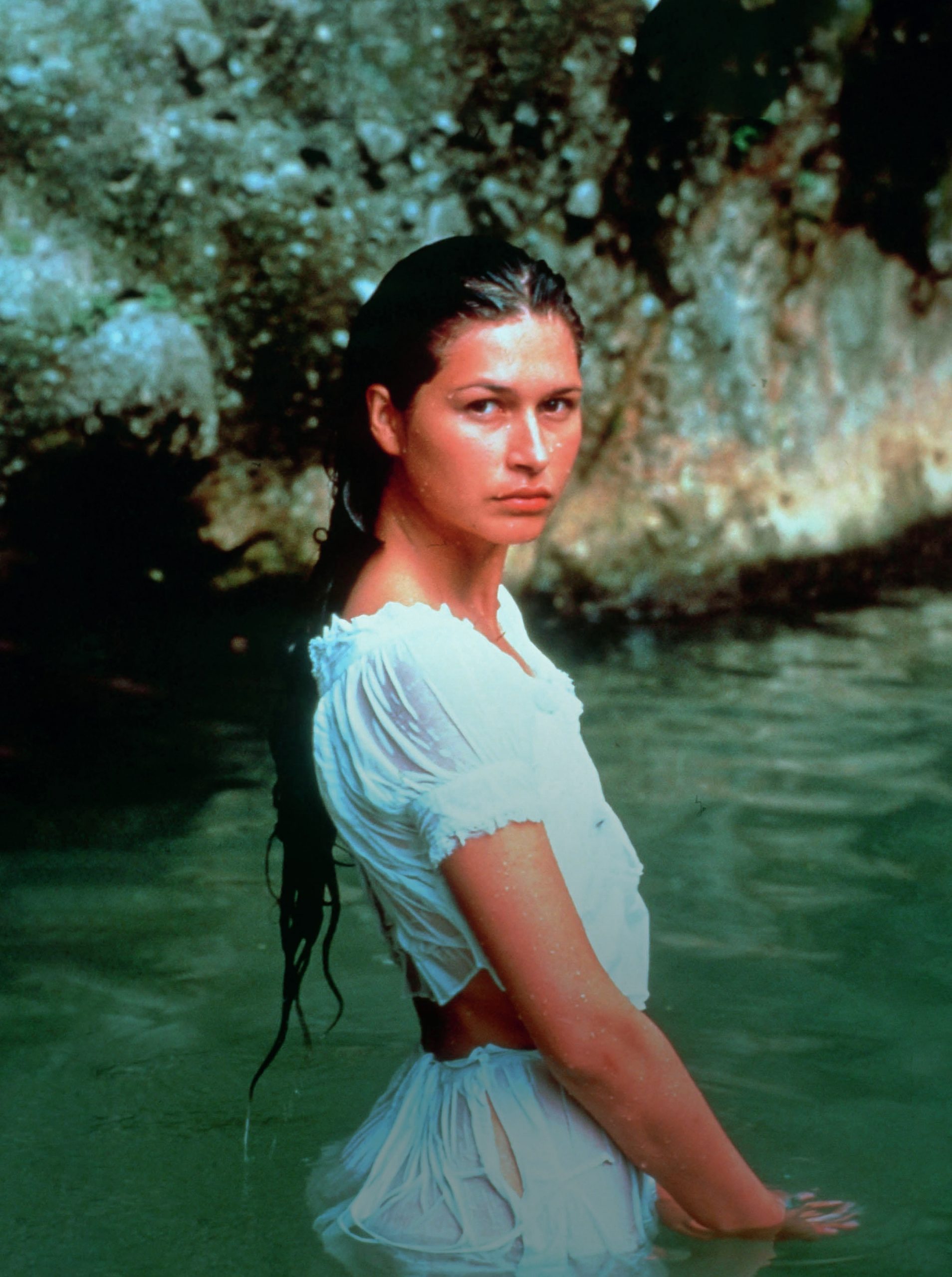 Film still of young Antoinette, standing in the sea in the Caribbean and looking thoughtful.