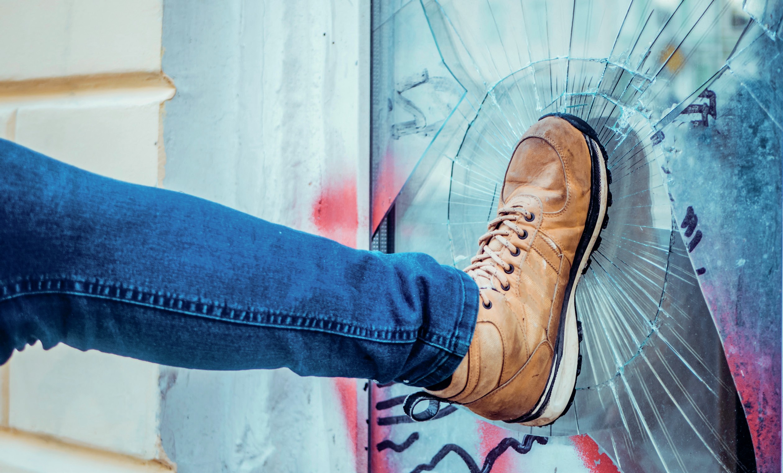 Foot shatters a window pane.