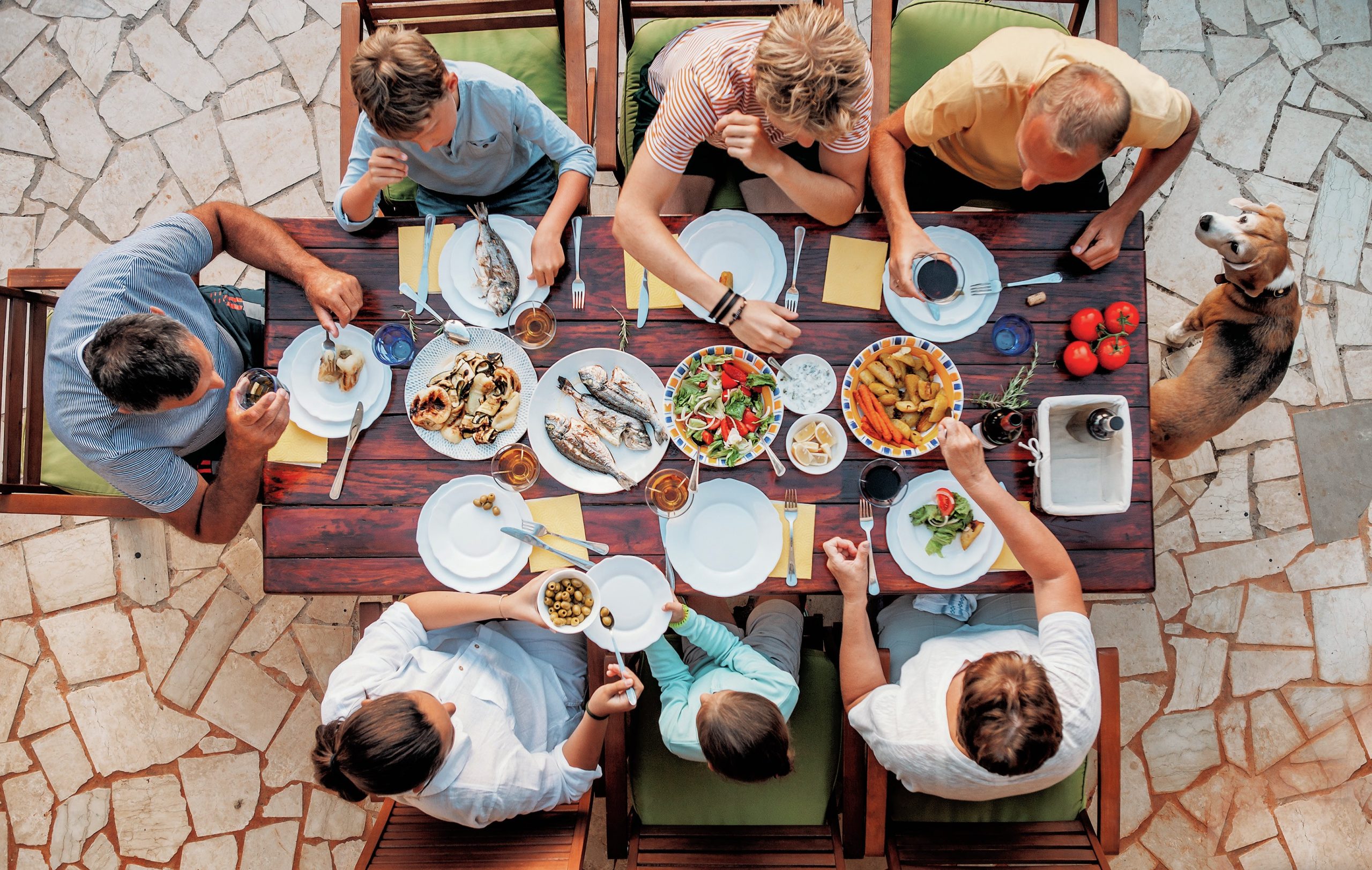 Overhead view of seven people sitting at a table for dinner.