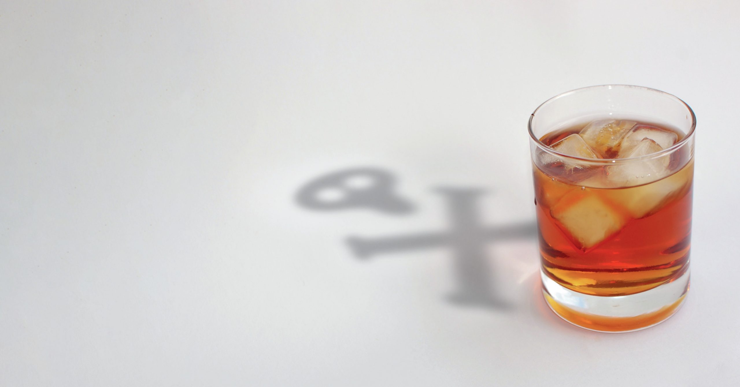 A drink with a skull and crossbones shadow behind it.