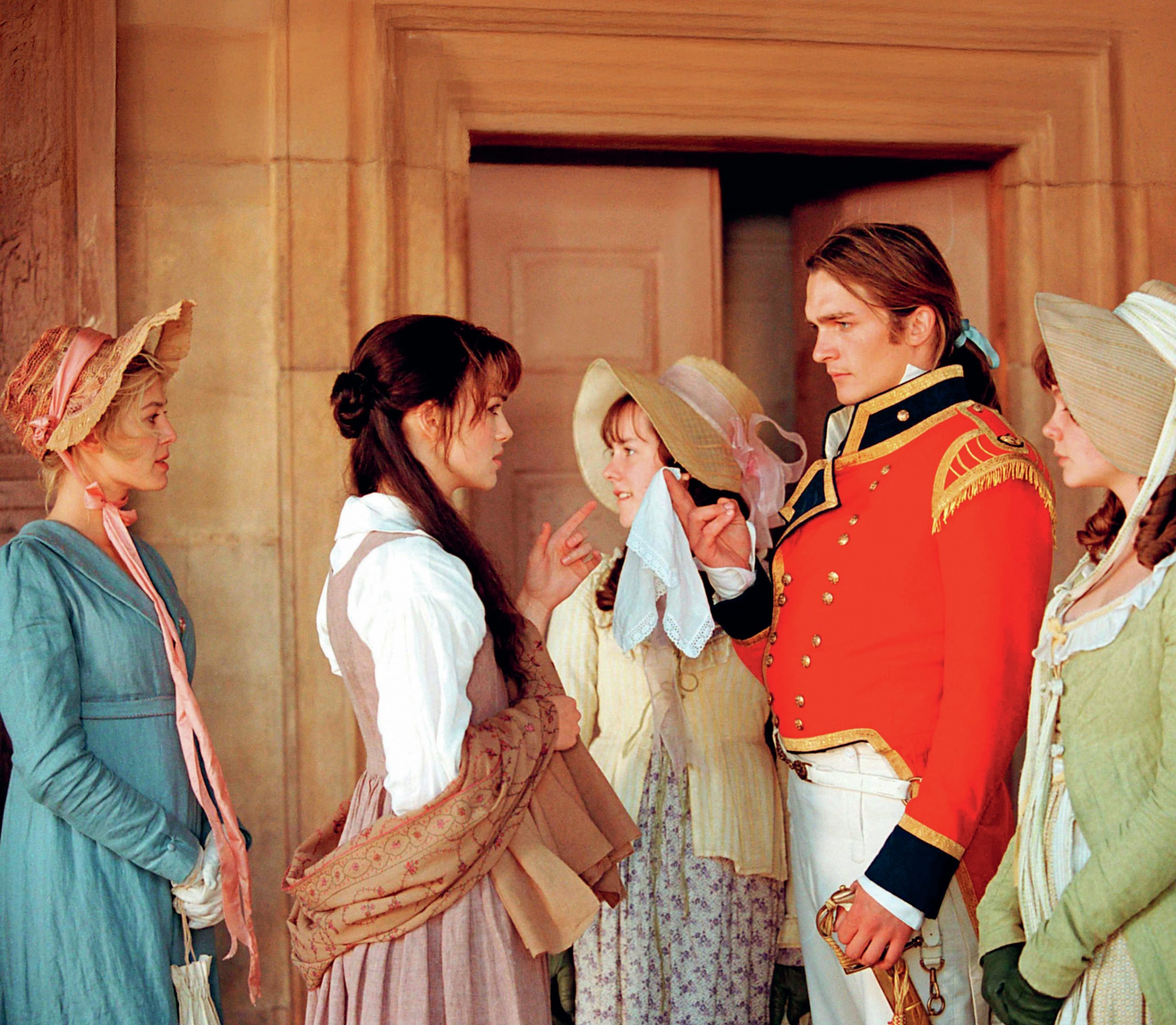 Wickham is wearing red military uniform and four Bennet sisters are around him. He is in conversation with Lizzie Bennet.