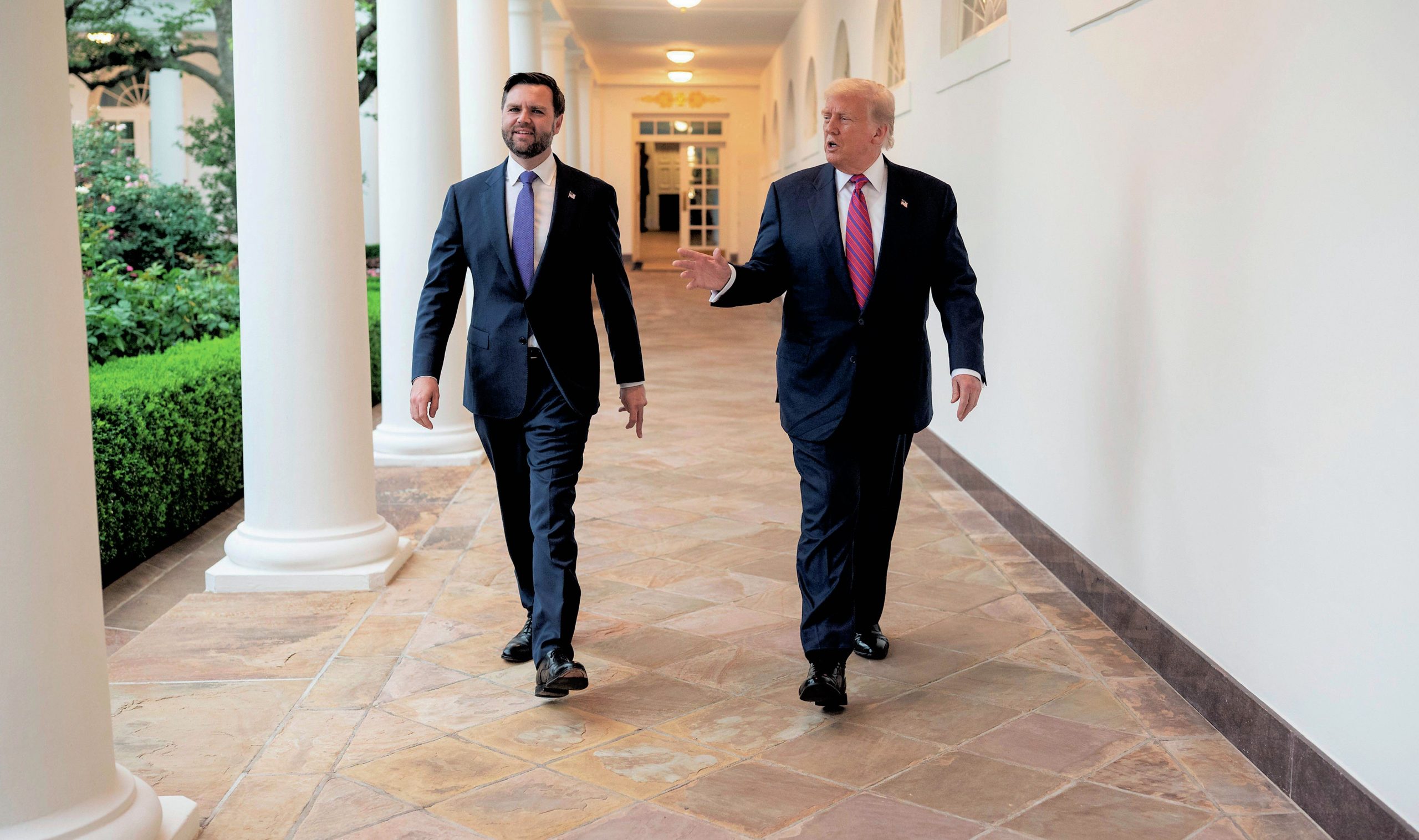 Vance and Trump walking along a corridor at the White House.