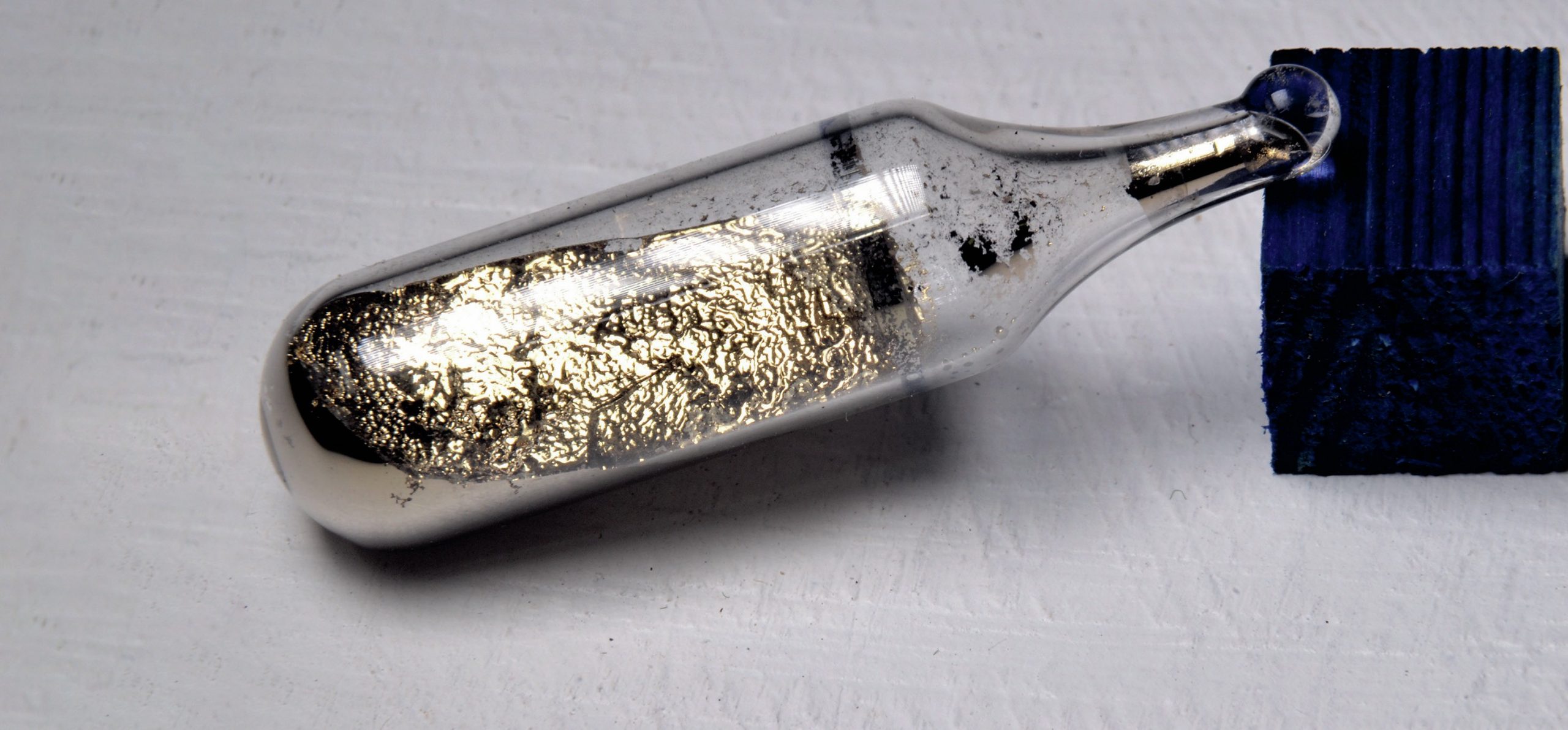 A glass vial containing a metallic substance
