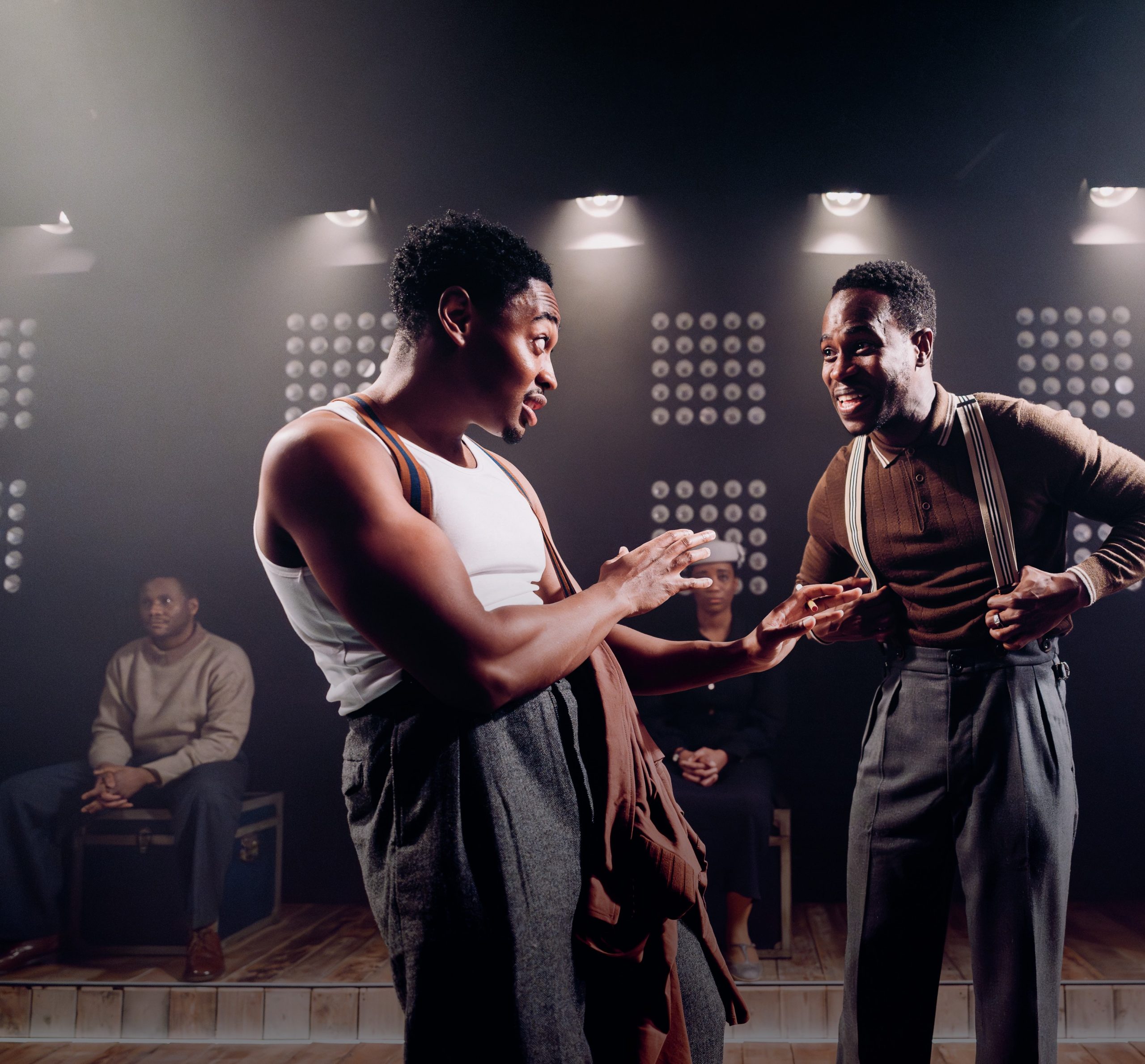 Two of the characters on stage talking to each other.