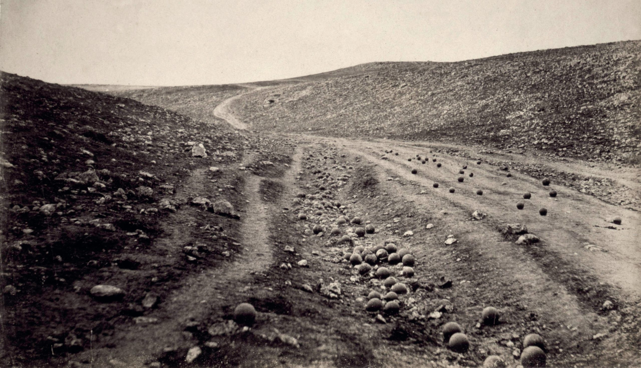 A road with no buildings nearby. There are many cannonballs on the road.
