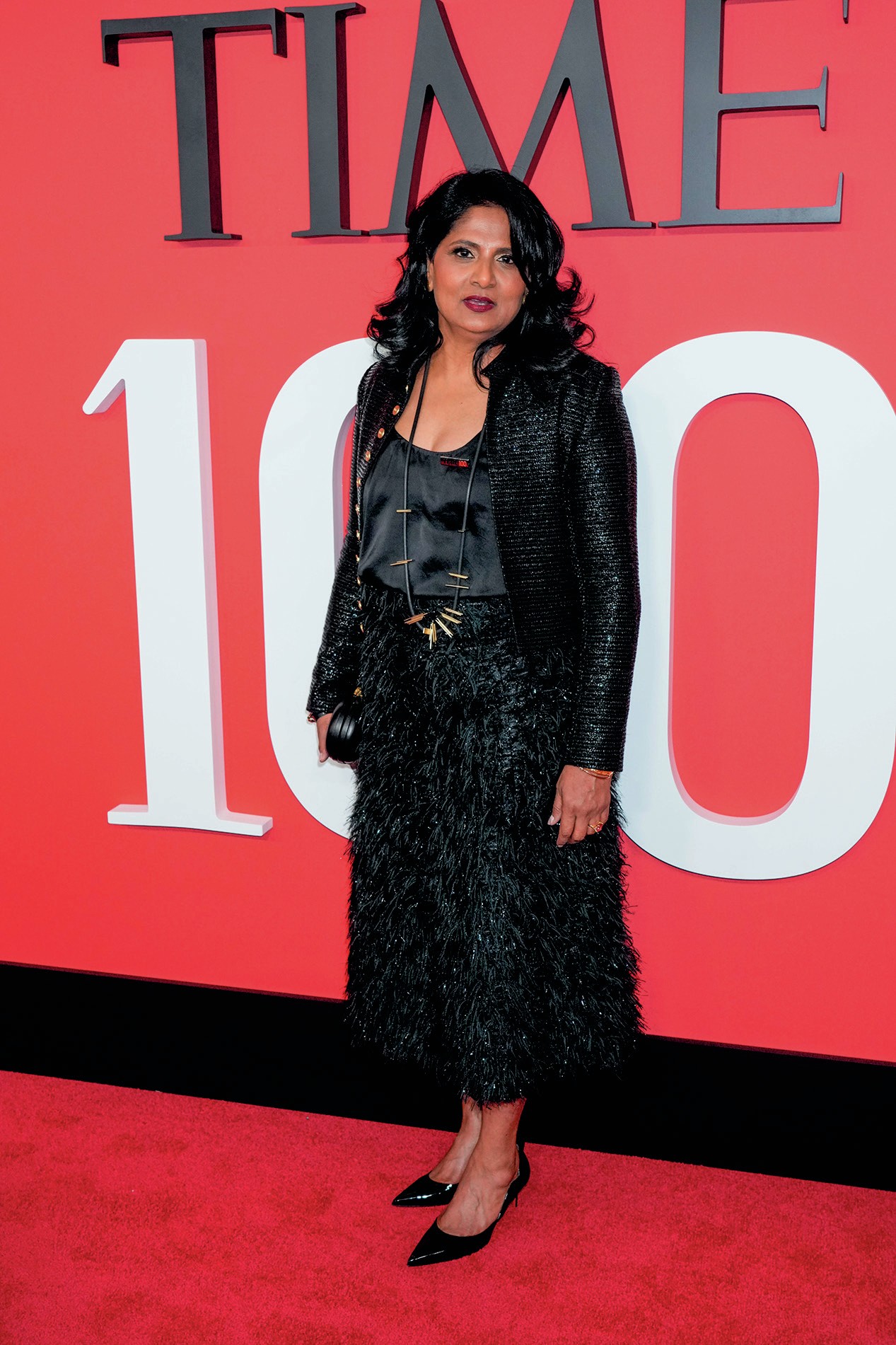 A woman wearing an evening dress standing on a red carpet at an event